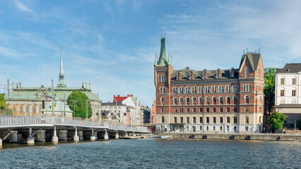Fototapeta premium View from City Hall overlooking Riddarholmshamnen Island, with Centralbron bridge, mediating Norstedt Building, or Norstedtshuset, and House of Nobility, or Riddarhuset, Stockholm, Sweden