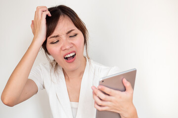 Fototapeta premium Upset angry asian woman using computer tablet showing negative disappointed expression