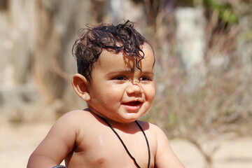 photo Portrait of happy baby boy with funny expression and looking away, Rajasthan India