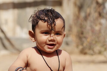 portrait of smiling baby with open mouth and looking ahead, Rajasthan India