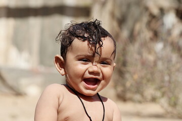 photo Portrait of Indian Cute baby boy playing outside nature and laughing at the camera, Rajasthan India