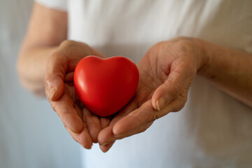 Obraz premium Hands holding red heart, healthcare, love, organ donation, mindfulness, wellbeing, family insurance and CSR concept, world heart day, world health day, national organ donor day