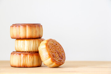 Traditional Chinese Mid-Autumn Festival mooncakes on a wooden platter isolated against white background