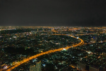 Aerial view of highway street road at Bangkok Downtown Skyline, Thailand. Financial district and business centers in smart urban city in Asia. Skyscraper and high-rise buildings at night.