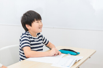 Naklejka premium 漢字の勉強をする小学生の男の子（笑顔・日本人） 