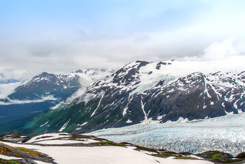 Spectacular mountain vista view of the snow capped Chugach mountains, glacier and valley from the top of Exit glacier in Seward, Alaska.