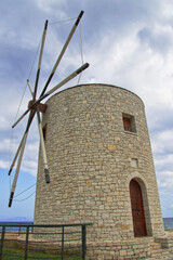 Seitlich schräger Blick auf die Windmühle von Korfu bei wolkigem Himmel am Tag, vertikal 