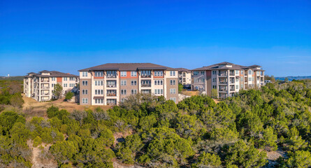 Fototapeta na wymiar Austin, Texas- Mountain top with apartment complex buildings against the clear blue sky