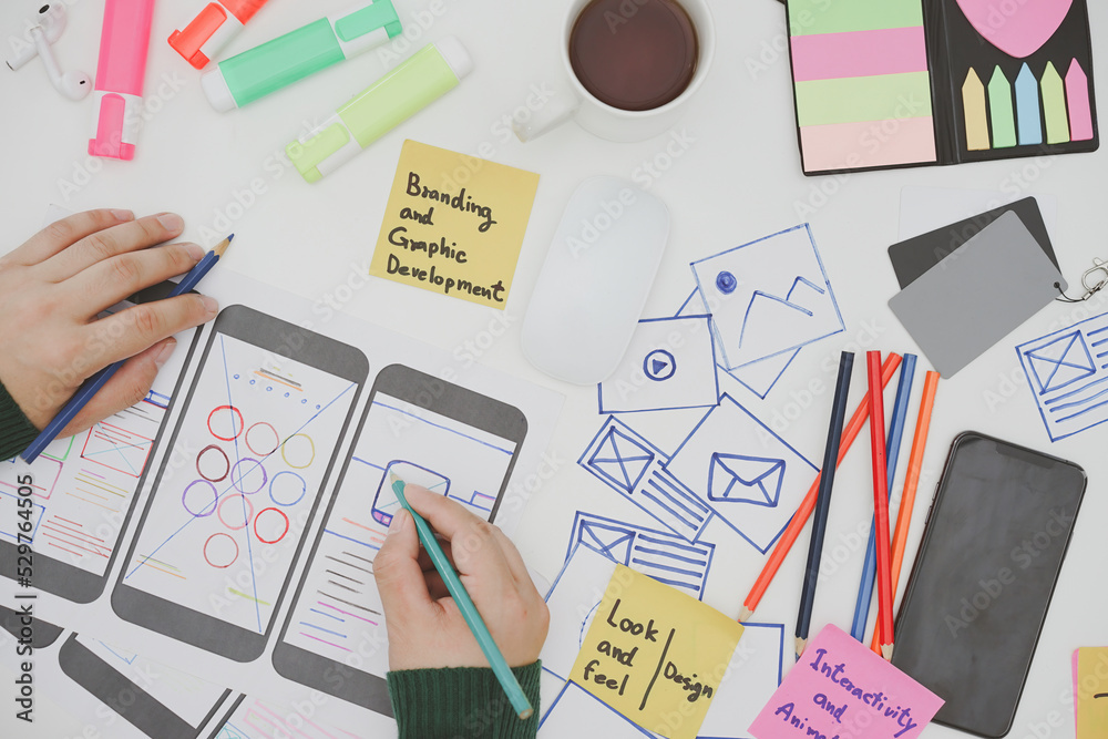 Wall mural creative designers designing wireframe sketch layout design mockup on smartphone screen. user experi