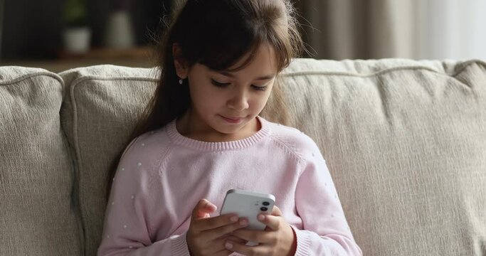 Internet addicted gen Z girl focused on smartphone using, playing virtual game on mobile phone at home, reading, chatting online, typing message, browsing internet alone. Cyber security concept