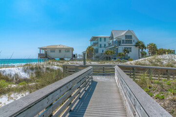 View of beach houses from a wooden boardwalk on a beach at Destin, Florida