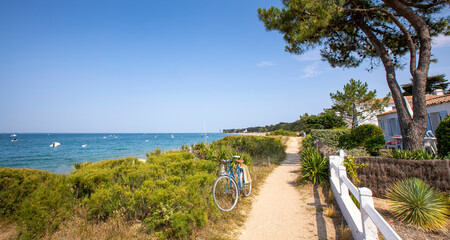 Vieux vélo bleu sur un sentier en bord de mer sur l'île de Noirmoutier en France.