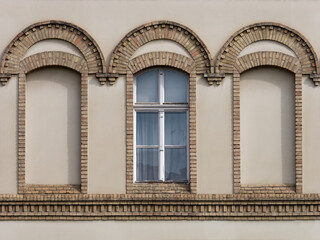 Fototapeta na wymiar Front view of a vintage-style window on a brown facade