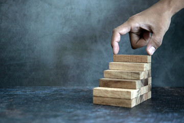 Hand place wooden block stacked concept of prevent collapse or crash of financial business and risk...