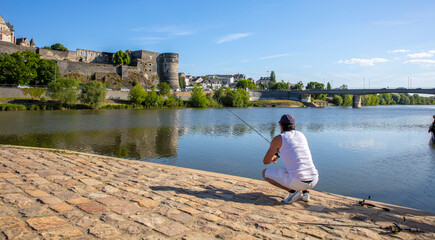 Pêcheur sur les bord de la Maine en Anjou au pied du chateau d'Angers.