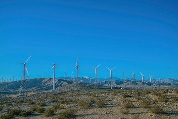 Wind turbines with tubular and lattice towers on a desert at California