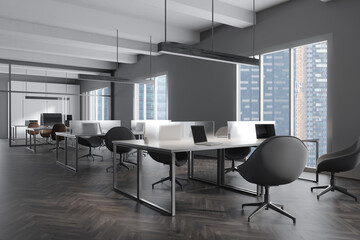 Fototapeta na wymiar Grey office interior with laptop and pc computer, panoramic window