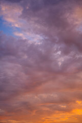 Naklejka na ściany i meble Beautiful bright multicolored sunset sky with yellow and pink hues, natural abstract background. Vertical shot
