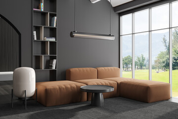 Grey chill interior with couch and coffee table in the corner, panoramic window