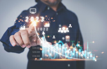 Businessman touching the virtual screen to high growth graph to year 2023 with copy space. Planning strategy investment, and marketing for high profit. Business, Investment, and financial concepts.
