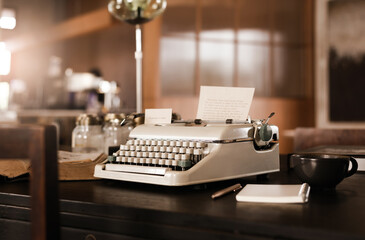 Fototapeta na wymiar Old typewrite with coffee cup and book on wooden desk in old office room, retro style, vintage color tone