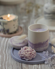 Soy candle in a concrete, plaster candlestick, decor interior. Home decoration with a burning scented candle. Spa. Natural.