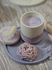 Soy candle in a concrete, plaster candlestick, decor interior. Home decoration with a burning scented candle. Spa. Natural.