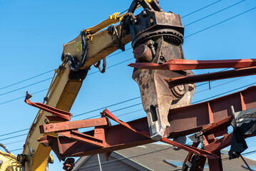 Demolition machine cutting steel frame, construction industry