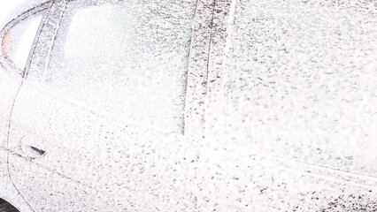 someone washes a car with foam at a car wash
