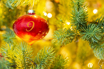 eine rote Weihnachtskugel mit einer Zahl (9) am Weihnachtsbaum, Weihnachtskalender