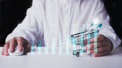 Man holding shopping cart and use technology to management the business, analyzing market business graph.