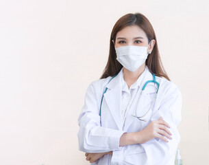 Asian female doctor stood wearing a white robe, wearing a mask and stethoscope.