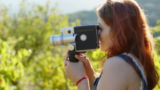 Happy girl recording a video with vintage camera 