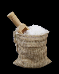 Sea salt in hessian sack with wooden scoop isolated on black background