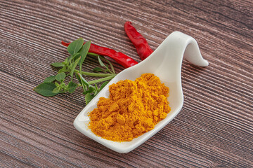 Yellow vibrant curcuma powder in the bowl