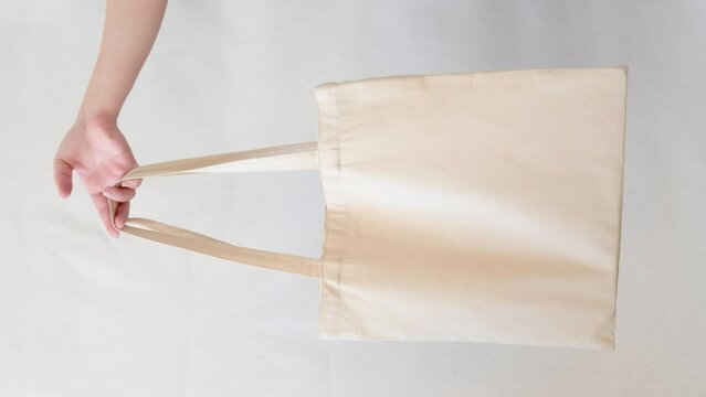 Hand with eco friendly shopper bag isolated on white background