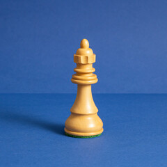 Wooden Queen chess, standing against  blue background. Chess game figurine. Leader success business concept. Chess pieces. Board games.