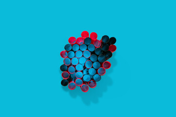 Top view on a bunch of red and black straws against blue background