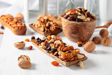 Fototapeta na wymiar Mix of nuts and raisins on a white wooden table.