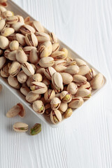 Salted pistachios on an old wooden table.