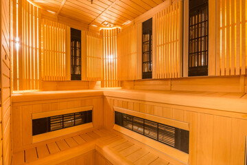 Infrared sauna. Interior design of a wooden, softly lit sauna with benches.