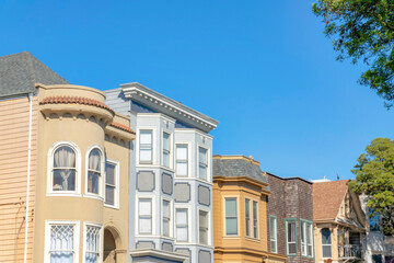 Row of houses with different structures against the clear blue sky in San Francisco, California