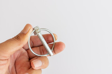 Lynch pin holding in hand on a white background with selective focus