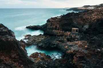 Beautiful coastal seascape scenery with fisherman's shelter and cave at Charco del Palo, Lanzerote, Canary Islands, Spain 