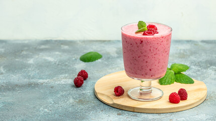 Yogurt smoothie with raspberries in glass on blue marble table. Natural detox. Long banner format