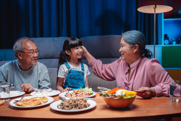 Asian happy family having lunch on dinner japanese table smiling together. little kid daughter enjoy eating food grandparents. Happiness time people lifestyle concept.