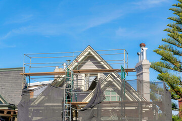 Unfinished house exterior with scaffolding covered with net in San Francisco, California