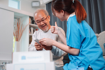 Asian senior male patient consult prescription drug with physician nurse at nursing home. Caregiver therapist pharmacist woman hold medicine pills bottle, medicine dosage at house in living room.