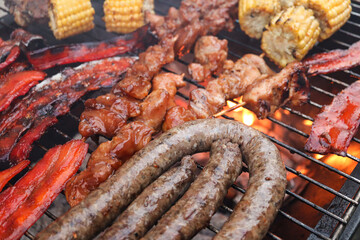South African braai with meat on the grill. Boerewors, chops, chicken kebabs,  bacon rashers and mielies on the braai. Braai day