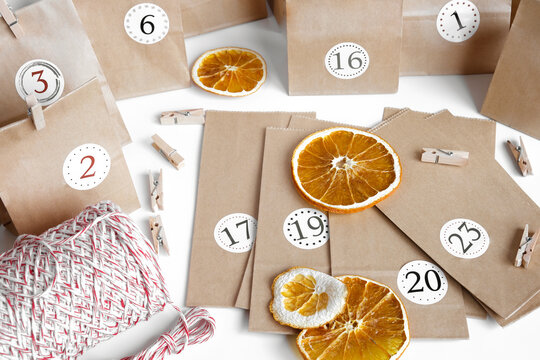 Christmas Advent Calendar. Paper bags, dry fruits, string on white table. Seasonal activity for kids, family winter holidays. Handmade tinkered calendar, natural material. DIY. Soft Focus. Top View.